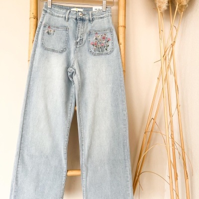 Calças de ganga azul claro com bordados florais nos bolsos