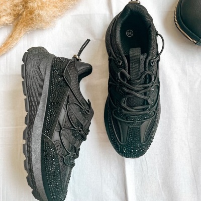 Sapatilhas pretas com strass sobre tecido branco