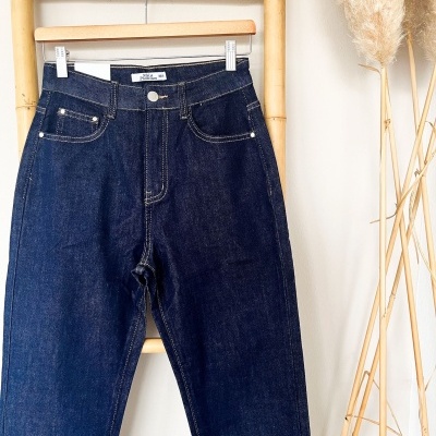 Calças de ganga azuis escuras penduradas numa escada de bambu