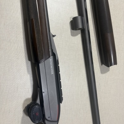 Espingarda Winchester desmontada sobre fundo claro