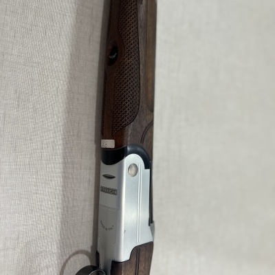 Arma de fogo com madeira castanha e caixa metálica prateada