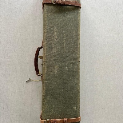 Estojo retangular verde com cantos em couro castanho e alça lateral