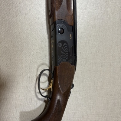 Rifle Beretta modelo 686 E em madeira castanha e metal preto com gatilho dourado