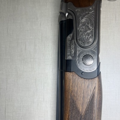 Espingarda Beretta com corpo em metal gravado e madeira polida