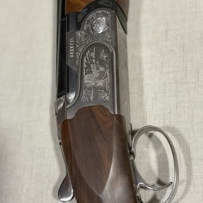 Espingarda de caça com detalhes em madeira e metal gravado