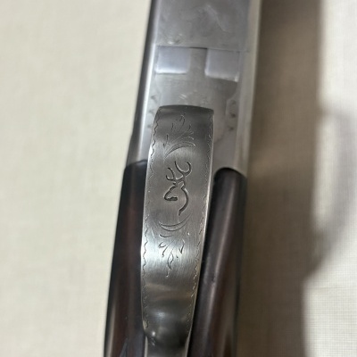 Espingarda metálica com gravuras e empunhadura de madeira escura