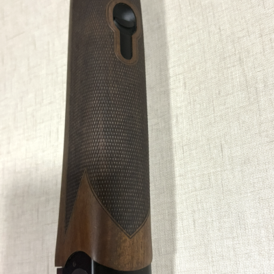 Coronha de arma de fogo em madeira castanha escura e metal preto