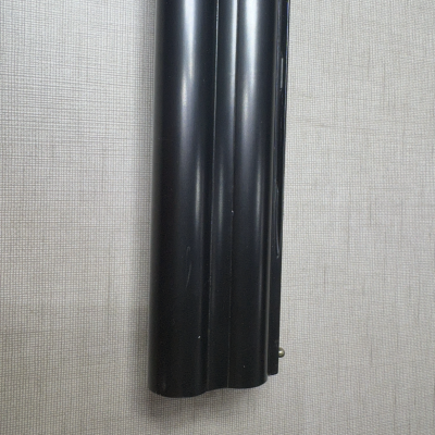 Cano duplo metálico preto contra parede cinza