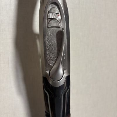 Mecanismo de metal prateado de arma com detalhes gravados e madeira castanha