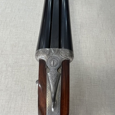 Espingarda de canos duplos com coronhas em madeira e detalhes metálicos gravados