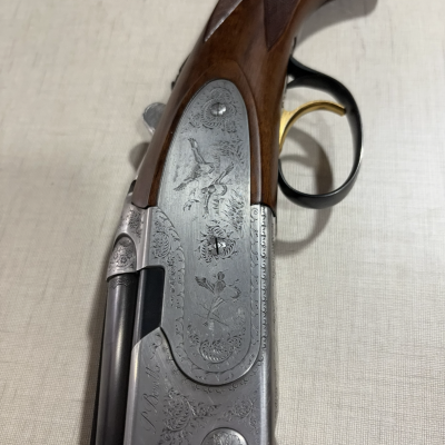 Espingarda de caça com detalhes gravados e coronha de madeira
