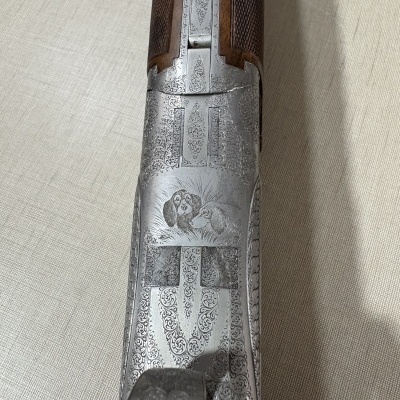 Espingarda de caça com gravações em metal e empunhadura de madeira