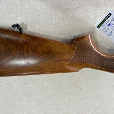Coroa de espingarda em madeira castanha com textura e etiqueta ao lado
