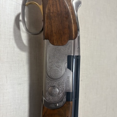 Espingarda Beretta com empunhadura em madeira e detalhes metálicos gravados