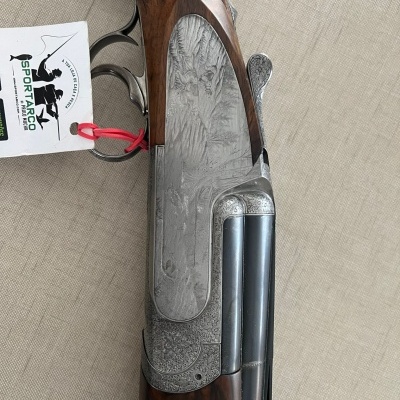 Espingarda de canos duplos com coronha em madeira escura e metal gravado