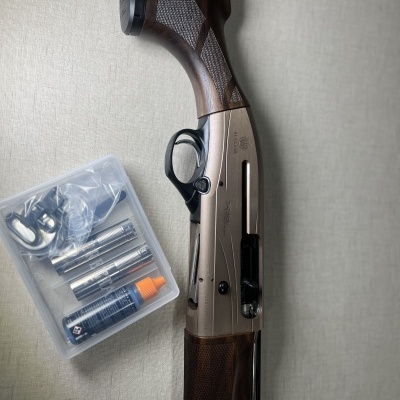 Espingarda com acessórios numa caixa plástica transparente