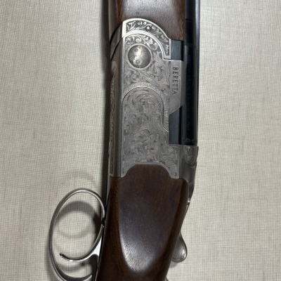 Espingarda com detalhes metálicos gravados e madeira castanha