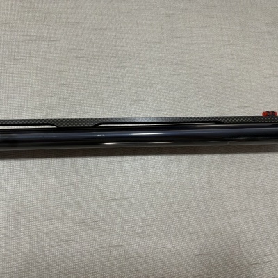 Cano de arma de fogo com acabamento preto e fibra de carbono e mira vermelha