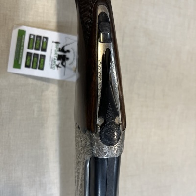 Espingarda de canos duplos com detalhes em gravação e madeira escura