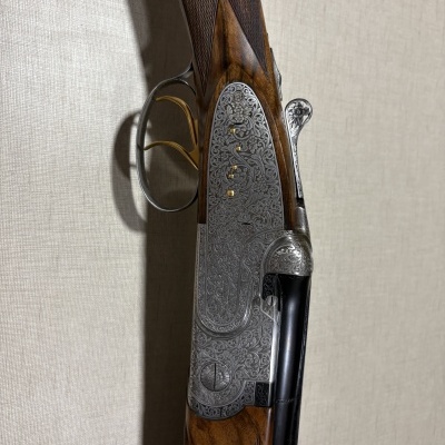 Espingarda de cano duplo com caixa gravada e coronha de madeira