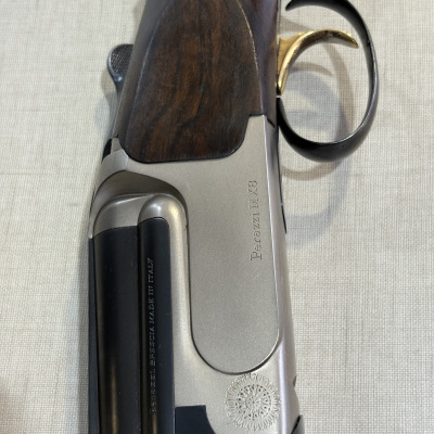 Caça com acabamento em madeira escura e detalhes metálicos com inscrições Perazzi MX8 e BERETTA BERG. - MADE IN ITALY