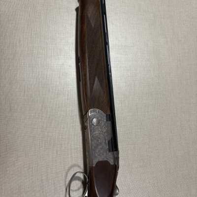 Espingarda Beretta com madeira e metal gravado sob fundo branco