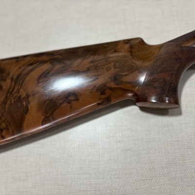 Coronha de madeira castanha polida com padrão natural e textura cruzada na pega.