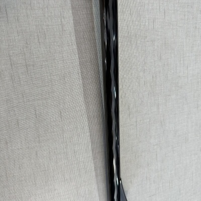 Cano de arma de fogo preto brilhante sobre tecido cinza