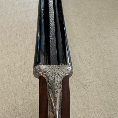 Espingarda canos duplos com madeira e metal decorado em fundo bege