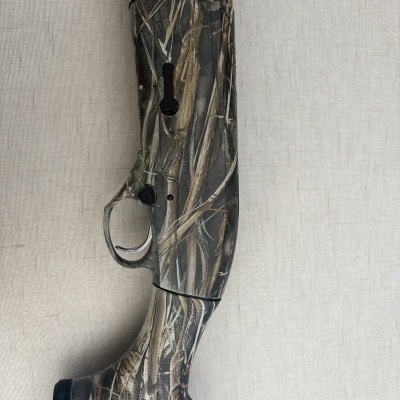 Corpo de arma de caça camuflada contra fundo cinza claro