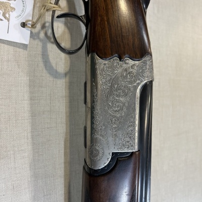 Espingarda de caça com detalhes em madeira e metal gravado