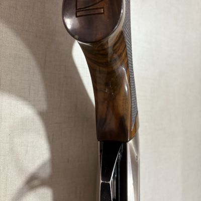 Coronha de espingarda em madeira castanha polida e metal preto com gravação