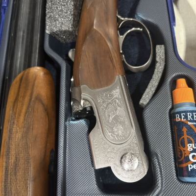Espingarda de caça Beretta com madeira polida e metal gravado em estojo com óleo lubrificante.