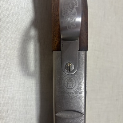 Arma de fogo com punho de madeira e metal gravado com texto BERETTA 999
