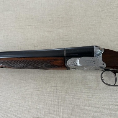 Espingarda de canos duplos com acabamento em madeira e metal gravado