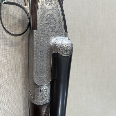 Espingarda de canos duplos com gravações detalhadas em metal e madeira escura