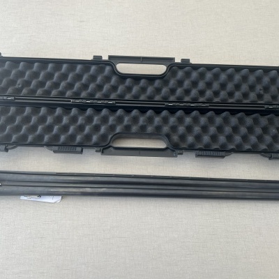 Estojo preto aberto com espuma e arma longa metálica preta ao lado