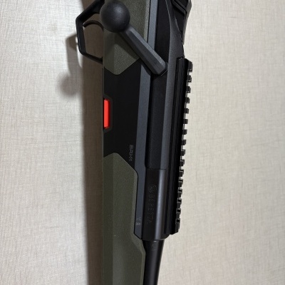 Rifle de ar comprimido Beretta preto e verde com botão vermelho encostado na parede