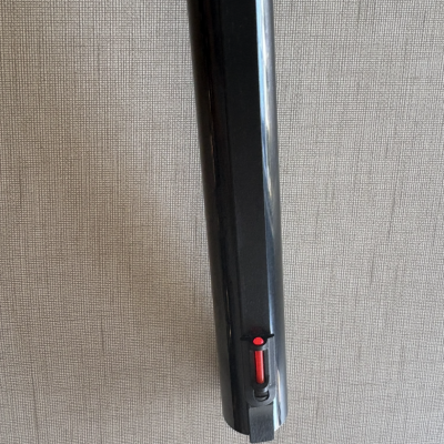 Mira dianteira vermelha em arma de fogo preta contra fundo bege texturizado