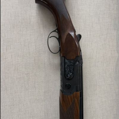 Espingarda com coronha em madeira escura e armação preta com gravuras e texto BREDA