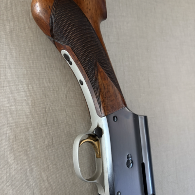 Parte da espingarda em madeira e metal com detalhe no gatilho dourado