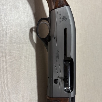 Espingarda Beretta semi-automática com coronha de madeira e corpo metálico prateado