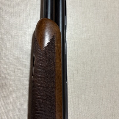 Espingarda com cabo de madeira texturizado e canos duplos pretos