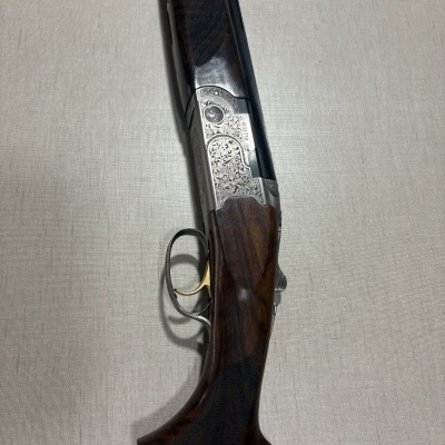 Espingarda Beretta com gravações detalhadas e coronha em madeira escura