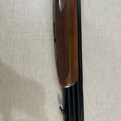 Espingarda com cano duplo em metal preto e empunhadura em madeira castanha texturizada