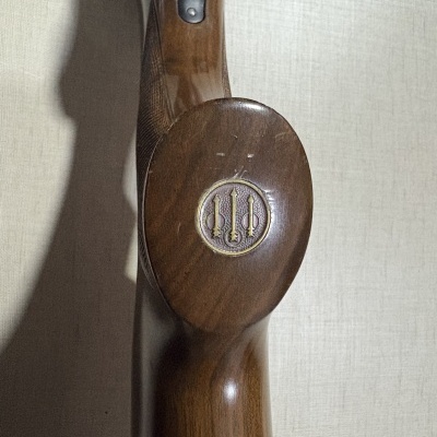 Coronha de madeira castanha com emblema circular e lanças douradas