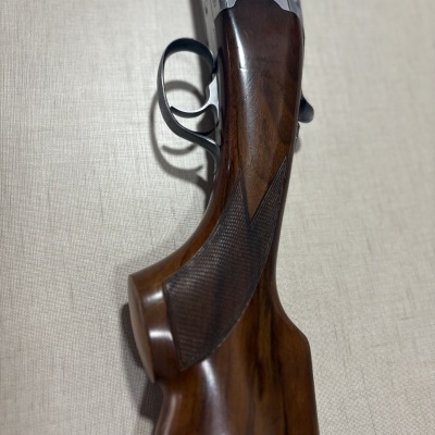 Espingarda com coronha em madeira escura e detalhes metálicos gravados