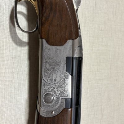 Espingarda Beretta com punho de madeira castanha e detalhes metálicos gravados
