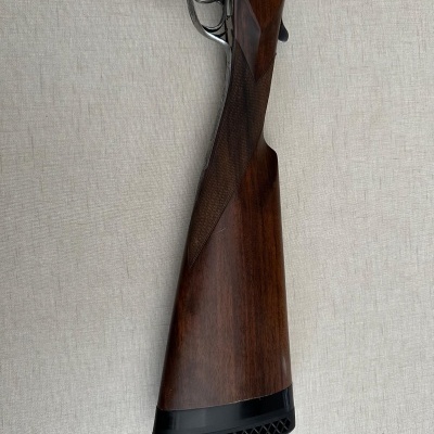 Espingarda com coronha em madeira castanha e punho metálico cinza