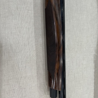 Espingarda de cano duplo com coronha de madeira escura e cano preto